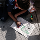 A Honduran child works in a coloring book while waiting with his family along the border bridge after being denied entry from Mexico into the U.S. on June 25, 2018 in Brownsville, Texas.